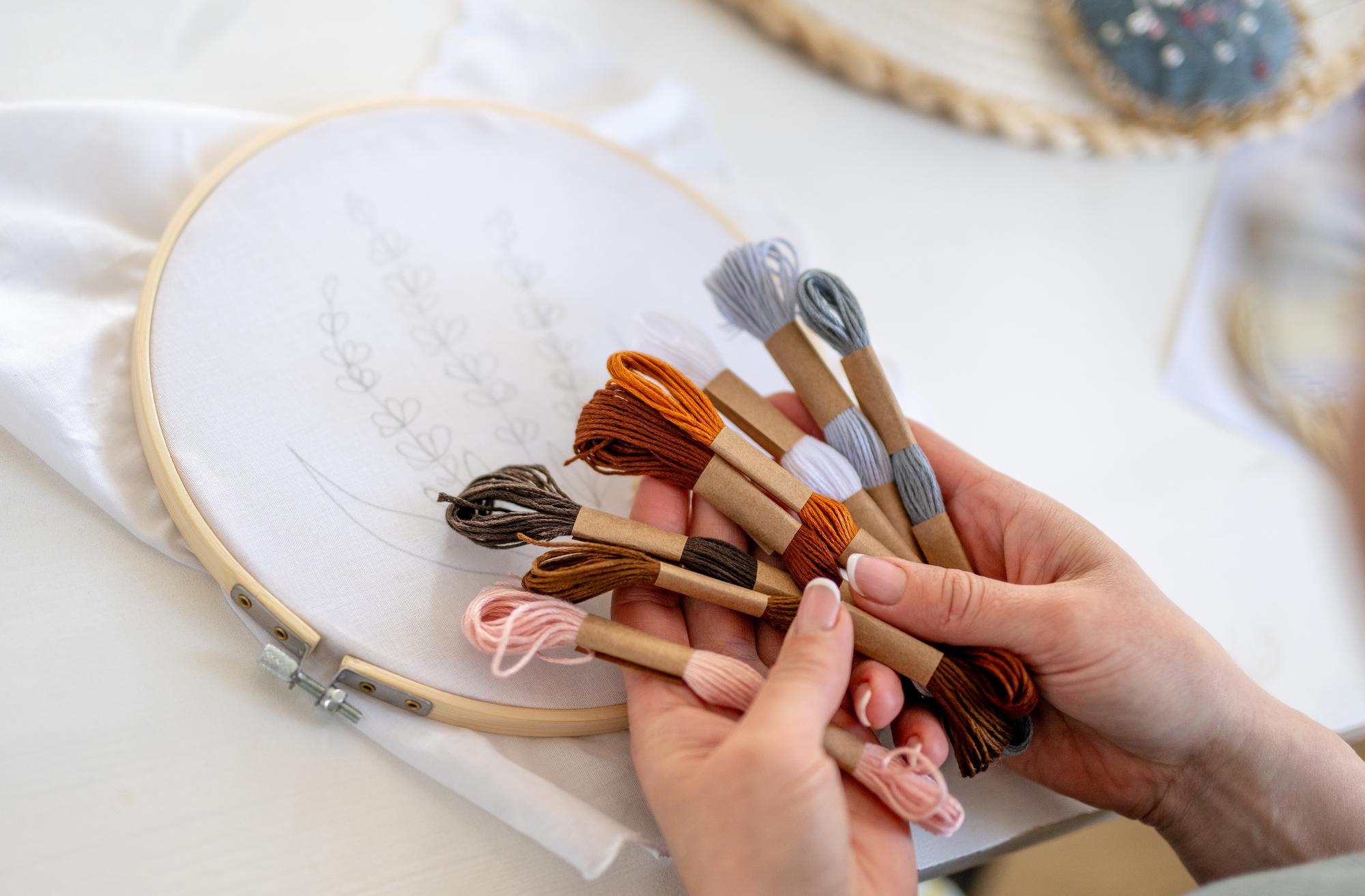 Artist hands embroidering a textile